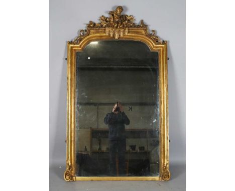 An impressive mid-Victorian giltwood and gesso overmantel mirror, the break arch top with a surmount of a central putto playi