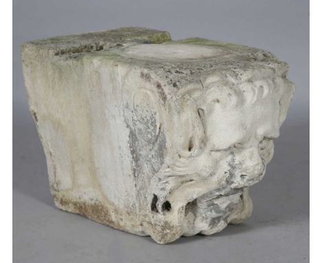 A carved architectural keystone, the front modelled with a green man mask, height 30cm, width 26cm, depth 49cm.