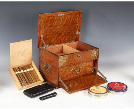 An Edwardian oak and brass mounted smoker's companion, width 31cm, the hinged lid enclosing a partial box of fifteen Davidoff