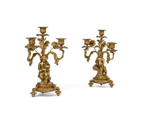 A PAIR OF GILT METAL THREE ARM FIGURAL CANDELABRA  19TH CENTURY The cherubs emblematic of The Seasons, signed to cast undersi