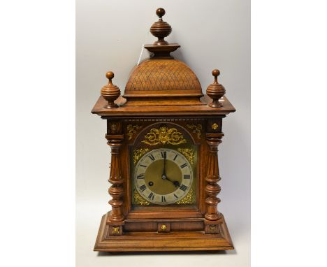 An oak Junghans bracket clock, brass dial with silvered chapter ring, Roman numerals, minute track, twin winding holes, 52.5c