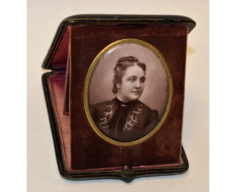 A porcelain oval plaque, printed portrait of young female, fitted tooled leather case