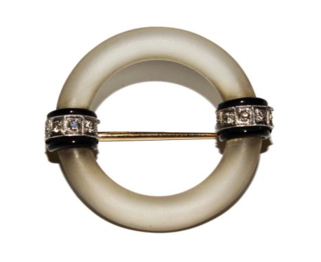 A 1920's Cartier brooch formed of a rock crystal circle with two bands of black enamel and diamonds. Signed to the back 14K C