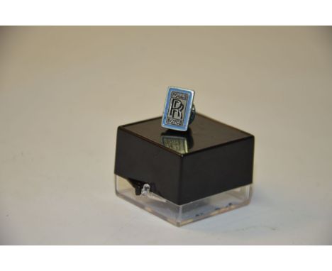 This item is a Rolls-Royce Logo Lapel Pin. The Pin is silver with black lettering and a blue border. 
