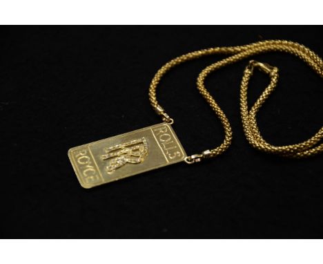 The piece features a rectangular pendant in solid 18 k gold with a polished surface. The pendant is engraved with the Rolls R