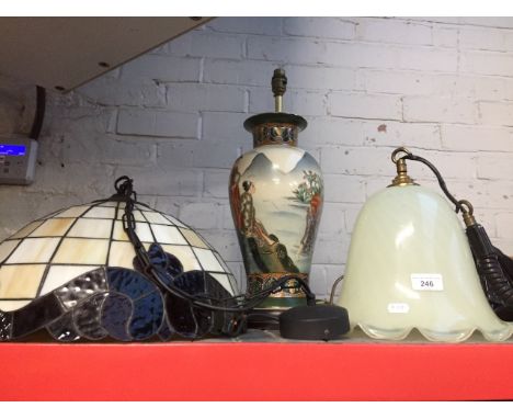 A tiffany style light shade, a glass lightshade and an oriental lamp 