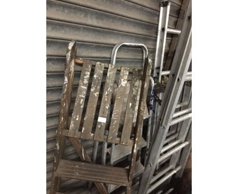 A pair of aluminum step ladders, a set of wooden stepladders and 3 way ladder. 