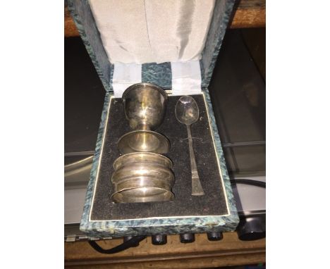 A cased child's christening set, plated cup and spoon and a silver napkin ring. 