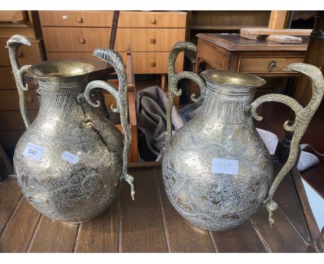 A pair of Indian brass vases decorated with hunting scenes and with cast cobra handles. 