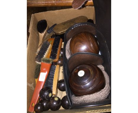 A box containing carpet bowls, brushes and a set of wooden crown green bowls in case. 