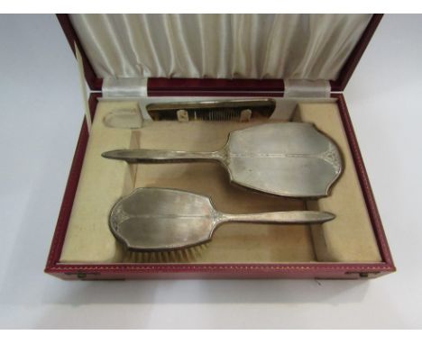 A cased silver backed mirror, brush and comb set