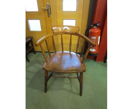 A circa 1900 elm and ash captain's elbow chair on ring turned supports and legs joined by stretchers