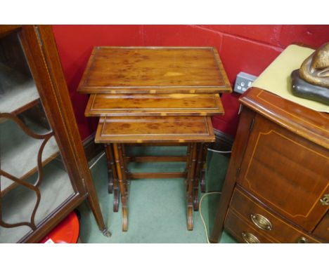 A 20th Century Georgian style nest of thee elegant occasional tables with ring-turned cylindrical legs and burr wood tops