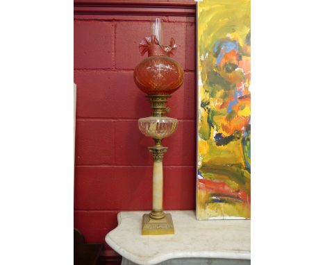 A Victorian corinthian column form oil lamp with cranberry frilled shade