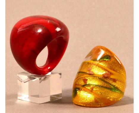 CLARE AUSTIN; two glass rings; red, ring size Q; yellow green and gold, ring size P (2). 

Provenance: Purchased from The Cra