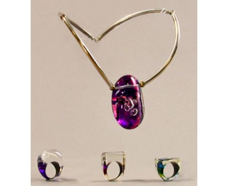 GAIL KLEVAN; an acrylic 'pebble' neckpiece, metal mount, drop length 19cm; with three acrylic rings, ring sizes O, Q and T (4