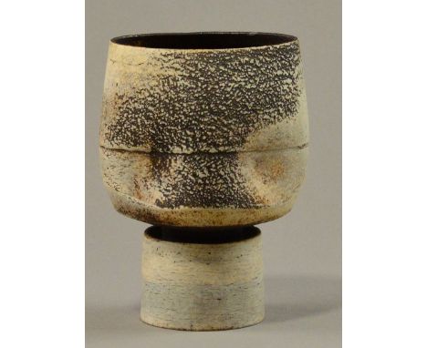 HANS COPER (1920-1981); a stoneware flower holder, oval and pinched bowl form on drum base, white slip over textured manganes