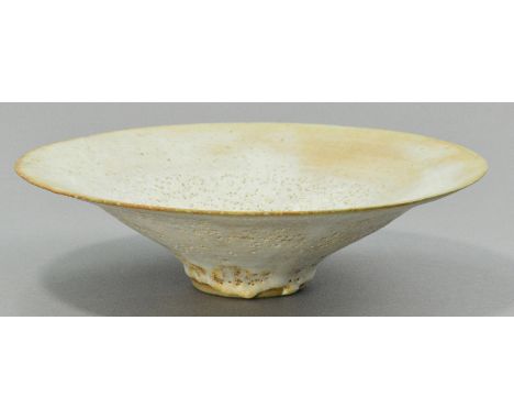 LUCIE RIE (1902-1995); a large stoneware footed dish of fared form, pitted cream glaze, impressed LR mark, made early 1970s, 