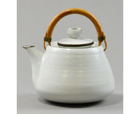 LUCIE RIE (1902-1995); a stoneware teapot, white glaze with manganese detail to spout and cover, cane handle and brass ferrul