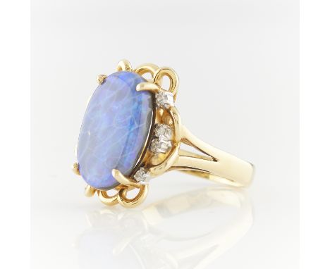 18k yellow gold opal ring with eight full cut diamonds set in white gold with yellow gold swirl details surrounding. Split sh