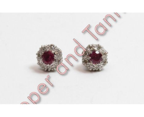 A pair of ruby and diamond cluster earstuds, in unmarked white metal, the round cut stones enclosed by single cuts