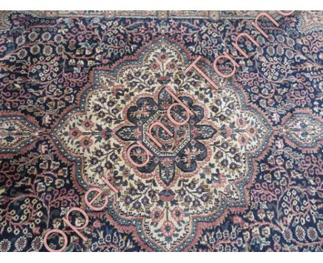 A silk Pakistani carpet on a blue ground with related flower motif border, 299cm x 80cm