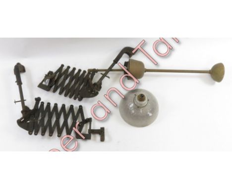 Two dentists extending metal arms, along with a glass shade and brass light