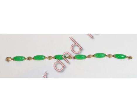 A jade bracelet, stamped '14k', the six long oval panels with oriental characters between, 19 cm long, 8.7 g gross