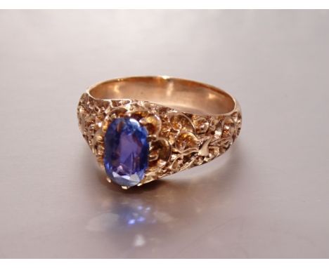 A yellow metal ring claw-set an oval violet natural sapphire of approximately 1.6cts, between chased shoulders, size T, 7.9g,