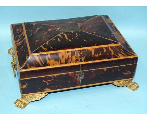 A Regency tortoiseshell sarcophagus-shaped box and cover, with gilt metal ring handles and winged paw feet, 25cm wide, (lock 