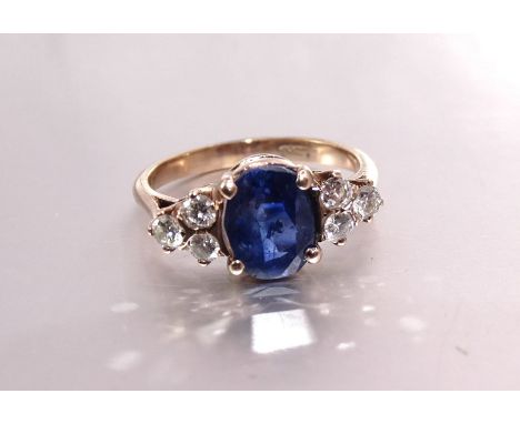 A sapphire and diamond ring claw-set an oval sapphire of approximately 2.3cts between triplets of brilliant-cut diamonds, in 