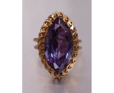 A gold dress ring claw-set synthetic purple sapphire, the mount bearing Middle Eastern marks for 18ct gold, size M, 6.4g. 