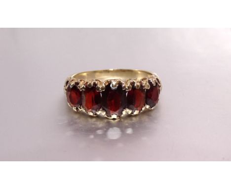 A 9ct gold ring set five graduated garnets, size P, 3.7g. 