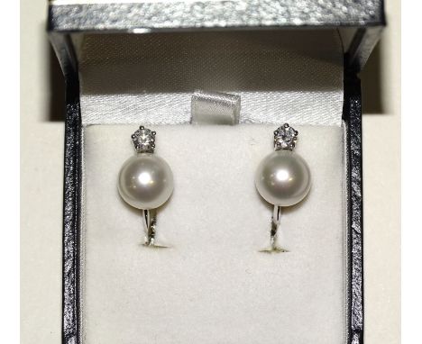 A pair of 18ct white gold pearl and diamond earrings, each earring set with a single pearl of approximately 9mm diameter belo