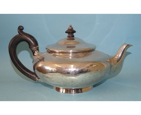 A George IV silver teapot of squat baluster form, with carved wood handle, on circular foot, maker Robert Garrard II, marked 