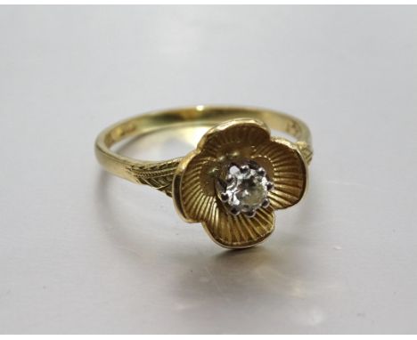 An 18ct gold ring claw-set a brilliant-cut diamond within a flower head, size N½, 3g. 