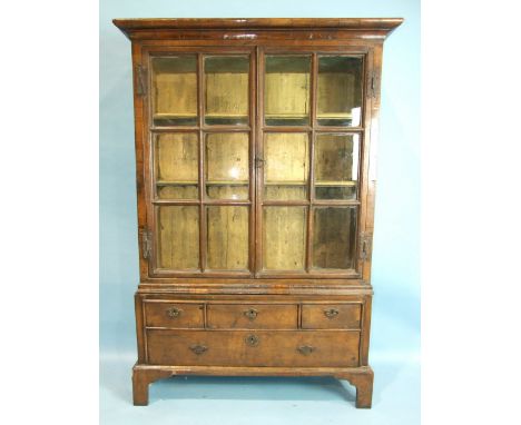 A 17th/18th century walnut and oak glazed display cabinet, having a pair of glazed doors, three small and a single long drawe