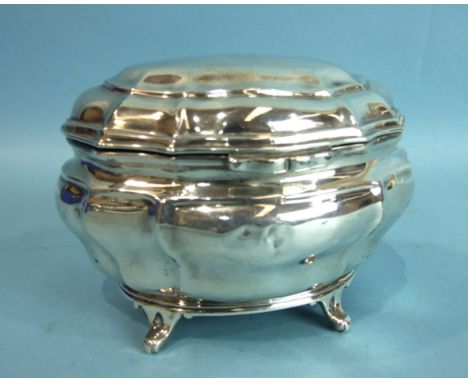 An Edwardian silver tea caddy of shaped oval form raised on four feet, 13cm wide, ___72.oz, (dents to front), maker Charles S