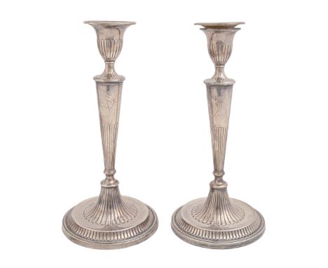 A pair of George III neo classical silver candlesticks, crested within chased cartouche, nozzles, 29.5cm h, marked on foot an