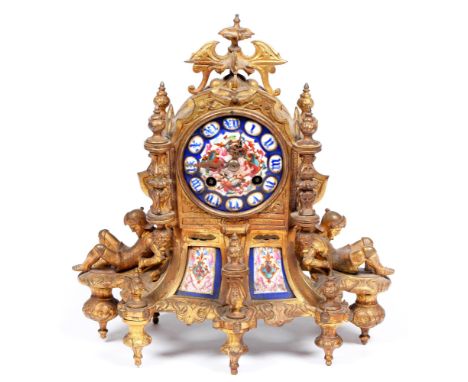 A French gilt lacquered brass mantel clock, 19th c,&nbsp;in Troubadour style, inset with porcelain plaques, the pillar shaped