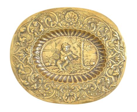 A German brass repousse dish, 17th c,&nbsp;with Putto blowing a horn within fluted cavetto, the border of strapwork and tulip
