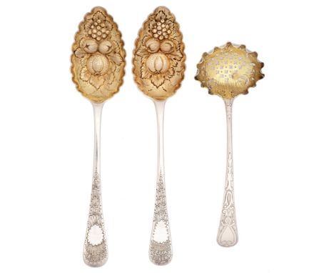 A pair of George III silver tablespoons and a sauce ladle, later chased and gilt as berry spoons, the ladle pierced as a sift