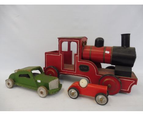 A large scale wooden model of a locomotive plus two wooden cars.