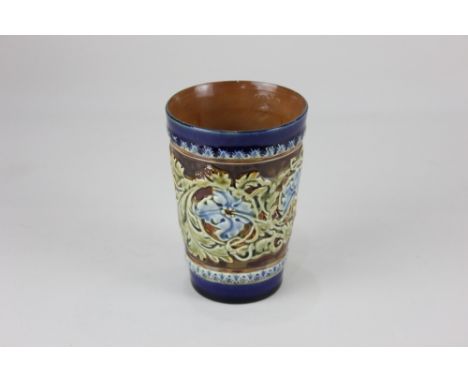 A Doulton Lambeth stoneware beaker, decorated in light relief with a border of blue flowers, birds and foliage, 11.5cm high