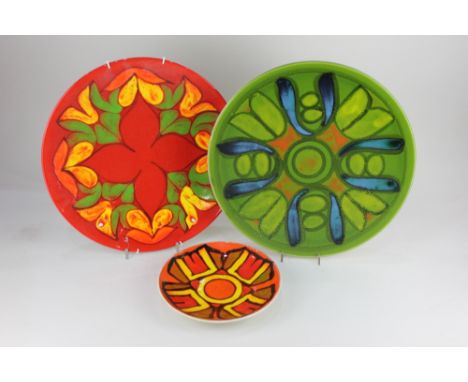 Two Poole pottery chargers, to include one decorated with a pattern on green ground, 35cm, together with a Poole pottery plat