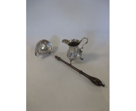 A George III silver cream jug and a toddy ladle  