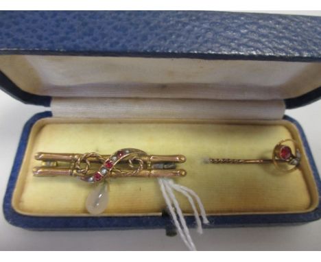 A 9ct double bar brooch set with rubies and pearls with a later added dropper, and a base metal stick pin with a ruby and pea