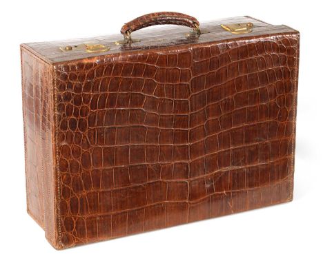 A GOOD VINTAGE BROWN CROCODILE SKIN STITCHED SUITCASE with padded silk lined interior and side pockets; fitted gilt brass sec