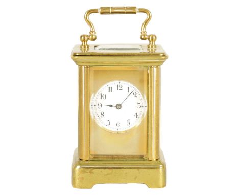 AN EARLY 20TH CENTURY MINIATURE CARRIAGE CLOCK the brass corniche case with masked enamel dial Arabic numerals fronting a jew