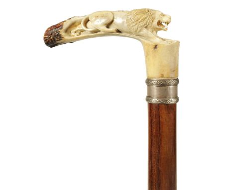 A FINE LATE 19TH CENTURY CARVED ANTLER HORN WALKING STICK the finely carved handle depicting a lion, with silver metal collar